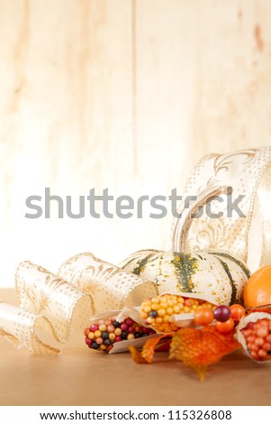 A group of gold and orange fall items sit against a wooden background.