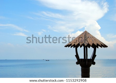 The wooden lanterns of the restaurant have a sea background and blue sky.