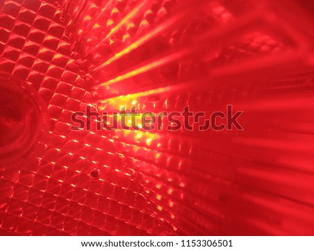 Abstract Blurred background of the Red Car Lamp. The Glass texture. Abstract out of focus lights coming from the Red Car Lamp. Abstract background of Red color. Close up. Macro. 