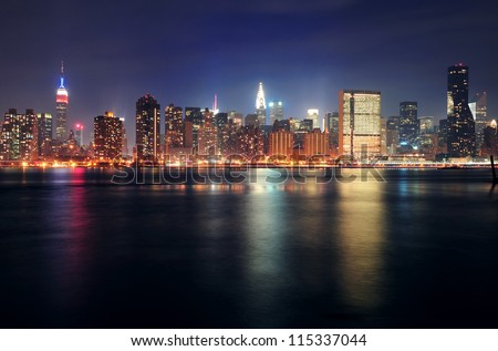 New York City Manhattan midtown panorama at dusk with skyscrapers illuminated over east river