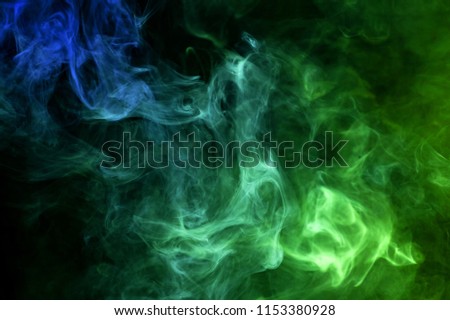Cloud of blue and green smoke on a black isolated background. Background from the smoke of vape
