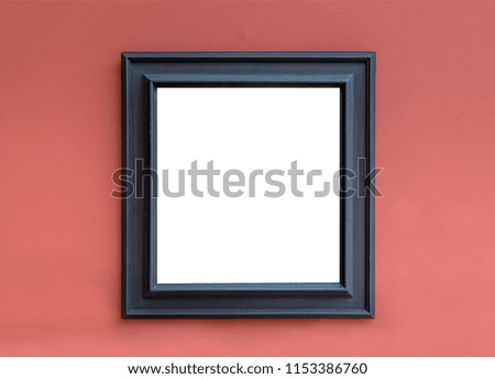 An empty picture with white background and black frame hanging on the red wall. A place for an inscription or image.