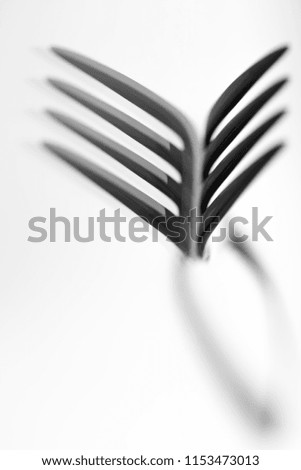 Macro photo of a single fork with its reflection in glass