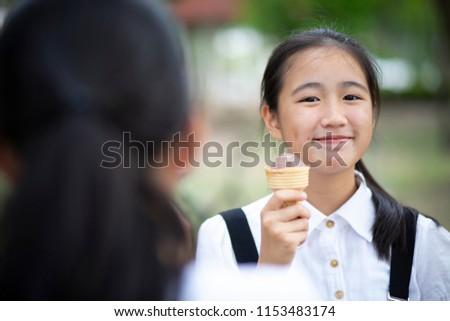 asian teenager eating icecream with happiness face 