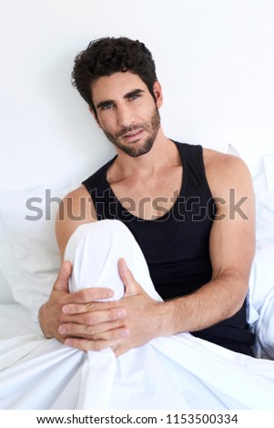 Dude in bed relaxing, looking to camera