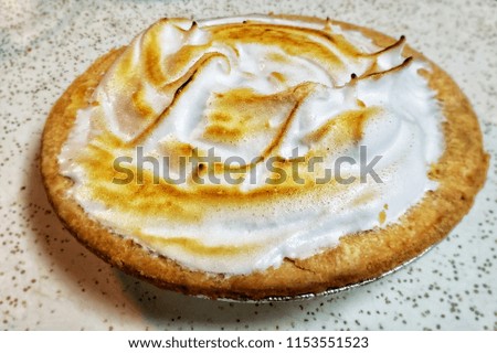 A whole Lemon Meringue Pie on a kitchen countertop