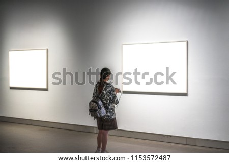beautiful asia girl in the gallery with blank frame