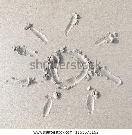 Sun drawn in the wet sand. Beach background. Top view