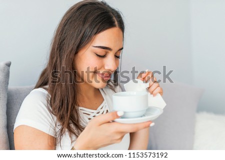 Cold. Closeup Of Beautiful Young Woman With Hot Cup Of Tea In Hands. Sickness And Illness. Portrait Of Sick Unhealthy Female Drinking Warming Yellow Drink Indoors. High Resolution