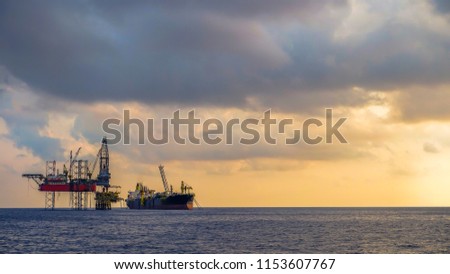 FPSO ship and drilling rig work on oil production platform offshore oil field view with beautiful cloud and blue sky background