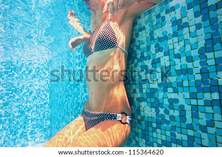 Underwater woman relaxing in swimming pool.