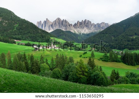 Beautiful view of countryside and green field with mountains background on summer from Dolomites, Italy.