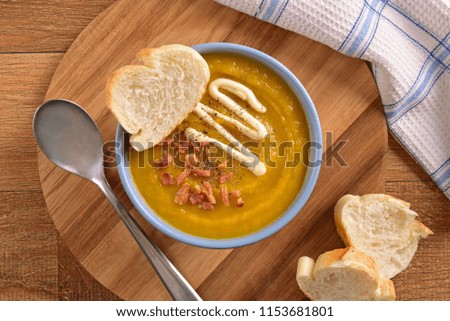 Pumpkin soup on wooden cutting board