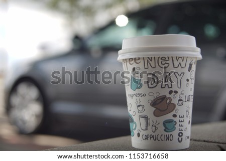 Сoffee in a painted glass on the background of cars