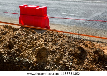 road red plastic block safety fencing repair work on the carriageway fencing of excavated pits repair sewage.