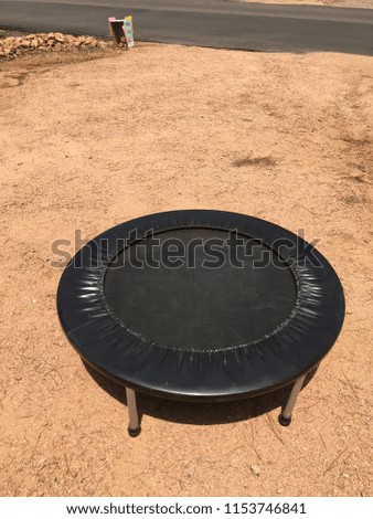Small round trampoline in driveway with Yard Sale sign in background