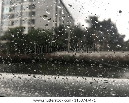 Rain drops on glass with grey sky background. Rain in the city