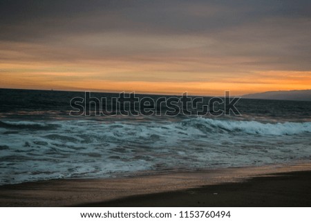 Cloudy infused sunset in summer over Santa Monica Beach in Los Angeles