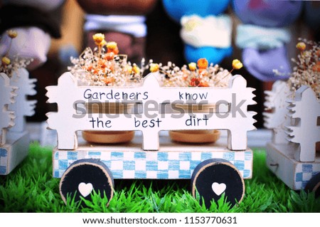 Painted wooden cart, blue and white, with little flowers bokeh and greetings message	