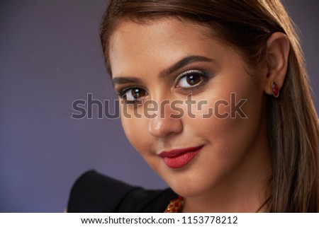 Heashot of attractive hispanic woman on dark blue background