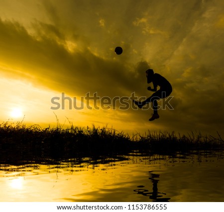 Silhouette Athletes playing football while the sun sets.