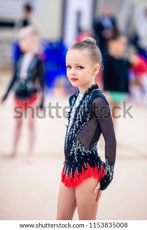 Adorable sporty little girl in rhythmic gymnastics
