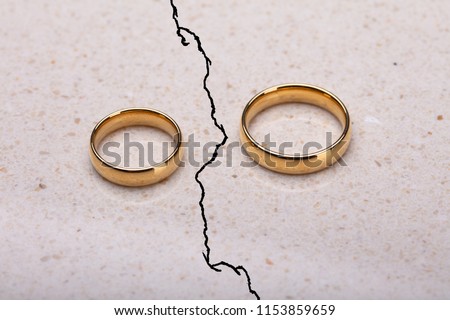 Two Separated Wedding Rings On Cracked Surface Royalty-Free Stock Photo #1153859659