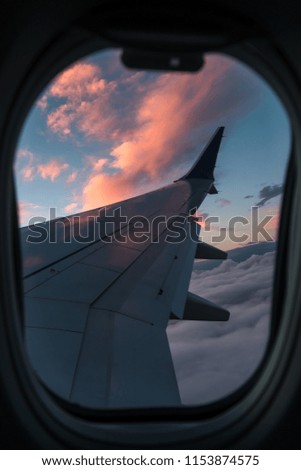 view from the airplane window to the wing, evening, sunset, clouds, concept of night voyages and travels, vertical photo