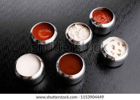 assorted sauces in tin cans for sauces isolated on a dark textured background. close up. top view. sauces isolated. dark background.