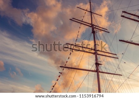 Close-up of Mast on traditional sailboats. Mast of large wooden ship. Beautiful travel picture with masts and rigging of sailing ship on blue orange sky background. Place for your own text. Göteborg