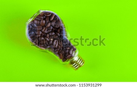 Bulb with roasted coffee beans inside over colored background for banner or idea concept