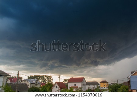 Thunderstorm clouds over a small town. Storm funnel clouds. Royalty-Free Stock Photo #1154070016