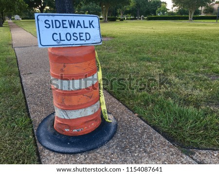Sidewalk closed sign on standing cone