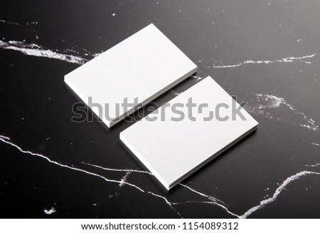 Photo of white business cards on black marble. Template for branding identity isolated on marble background. For graphic designers presentations and portfolios marble premium luxury mock-up. 