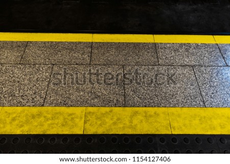 Close up from top view at yellow lines on train station.
