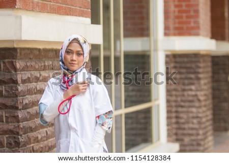 Young and attractive Muslim medical staff wearing hijab outdoor photoshoot 