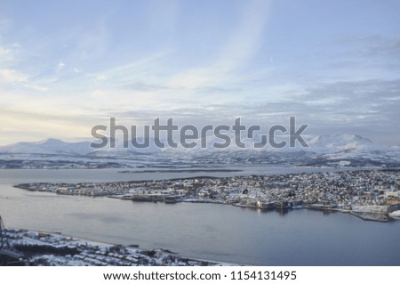 North of Norway in the vicinity of the city of Tromso view of the snow-capped mountains and fjord. Royalty-Free Stock Photo #1154131495