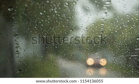 Road view through car windshield with rain drops, Driving in rain.