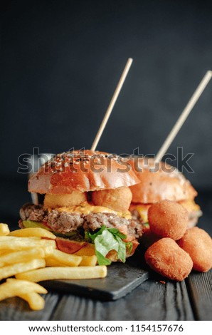 homemade juicy burgers on wooden board,  cheese balls. Street food, fast food.  with French fries and glass of  cola.