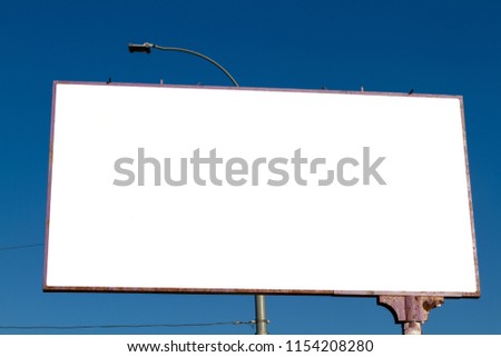 Big billboard with a lantern against a blue sky. Bigboard in the afternoon with a white blank background. White mock-up bigboard for advertising development. Blank display.