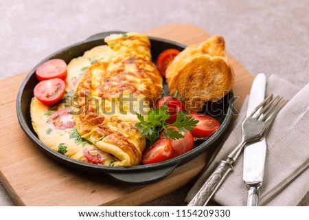 Herb omelette with chives, cherry tomatoes and parsley with panini toasts. Breakfast Royalty-Free Stock Photo #1154209330