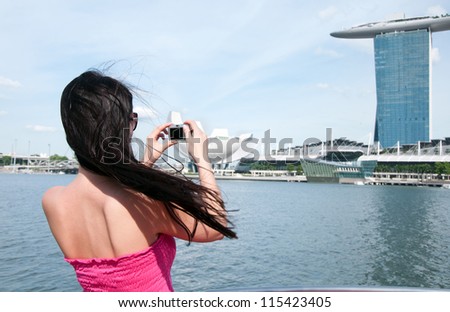 Young woman taking picture of Marina bay hotel in Singapore
