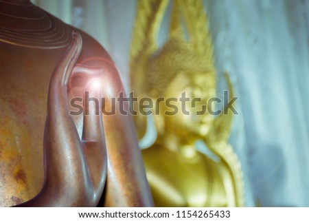 hand of buddha statue with yellow light.