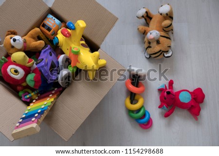 box of toys on the floor. Teddy bear in box,vintage tone. charitable contribution. donation. beneficence.