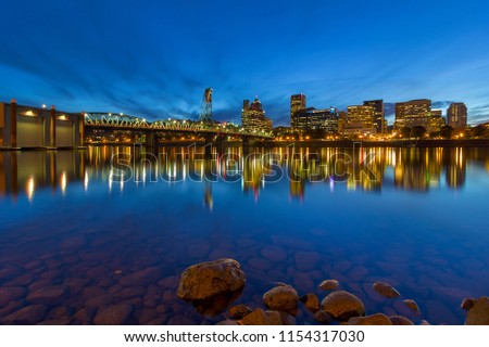 Portland Oregon downtown city skyline by Hawthorne Bridge from Eastbank Esplanade during evening blue hour