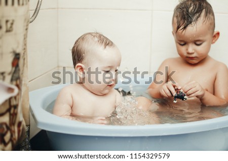 children, brother and sister in the bathroom swimming, playing splashing
