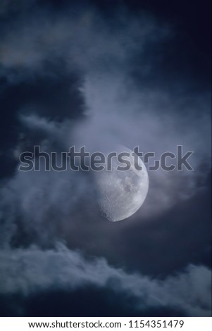 Halloween night sky with clouds and appearance of a full moon with craters close up