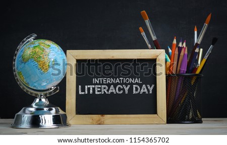 International Literacy Day. World Globe, School Stationary and Alarm Clock Royalty-Free Stock Photo #1154365702