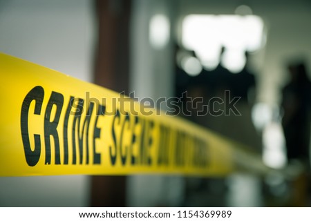crime concept by police line tape with blurred forensic law enforcement background in cinematic tone and copy space Royalty-Free Stock Photo #1154369989