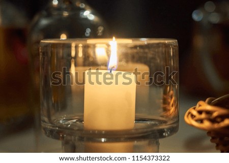                         Candle on a table with blurred background bokeh.       